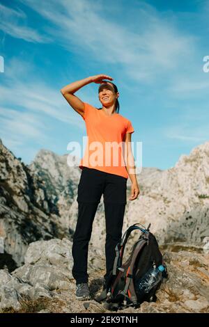 Frau, die die Augen abschirmt, während sie den Blick auf den Berg auf dem Cares Trail im Picos De Europe Nationalpark, Asturien, Spanien, betrachtet Stockfoto