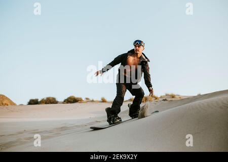 Junger Mann Sandboarding in der Wüste in Almeria, Tabernas, Spanien Stockfoto