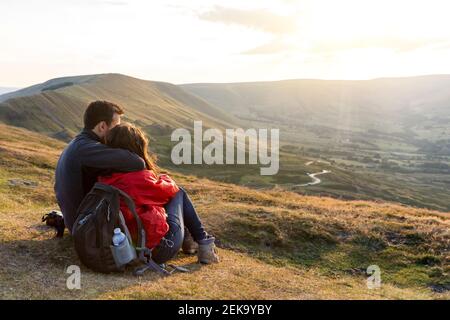 Junges Paar umarmt, während Blick auf Sonnenuntergang während der Ferien Stockfoto