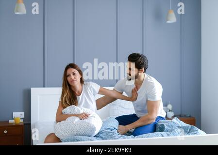 Junge gut aussehende Paar kämpfen in ihrem Schlafzimmer. Über ihre Probleme streiten. Stockfoto