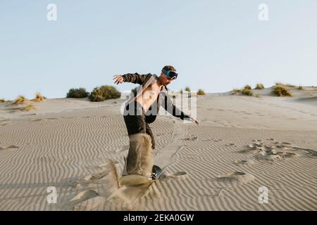 Junger Mann schneit auf Sand in Almeria, Wüste Tabernas, Spanien Stockfoto