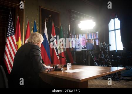 Premierminister Boris Johnson sieht sich eine Videoansprache von Sir David Attenborough bei einer Sitzung des UN-Sicherheitsrats für Klima und Sicherheit im Außenministerium, im Commonwealth and Development Office in London an. Bilddatum: Dienstag, 23. Februar 2021. Stockfoto