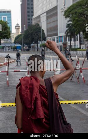 Ein Mönch macht während der Demonstration eine Geste.der Staatsstreich von Myanmar 2021 begann am Morgen des 1. Februar 2021, als demokratisch gewählte Mitglieder der Regierungspartei Myanmar, der Nationalen Liga für Demokratie, vom Militär der Tatmadaw Myanmar abgesetzt wurden, das die Macht in einer Stratokratie übernahm. Die Tatmadaw verkündete einen einjährigen Ausnahmezustand und erklärte, die Macht sei dem Oberbefehlshaber der Verteidigungsdienste Min Aung Hlaing übertragen worden. Sie erklärte die Ergebnisse der Parlamentswahlen vom November 2020 für ungültig und erklärte ihre Absicht, am Ende des Ausnahmezustands eine Neuwahl abzuhalten Stockfoto