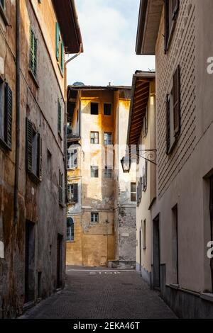 Leere schmale Gasse inmitten von Gebäuden in der Stadt, Valchiavenna, Chiavenna, Provinz Sondrio, Lombardei, Italien Stockfoto