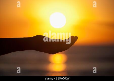 PersonÅ½s Hände Schröpfen unter untergehenden Sonne, Miami Beach, Florida, USA Stockfoto