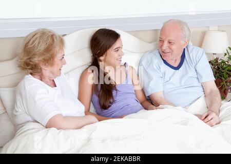 Familie liegt im Bett und lächelt Stockfoto