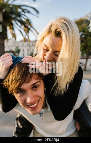 Junger Mann mit Freundin Huckepack Fahrt Stockfoto