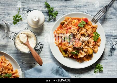 Zwei Teller Fliege Pasta mit Gemüse und vegan Parmesan Stockfoto