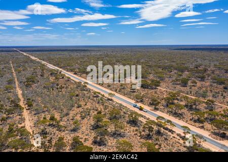 Luftaufnahme des Eyre Highway, der sich über den Nullarbor National Park erstreckt Mit klarer Horizontlinie im Hintergrund Stockfoto