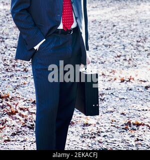 Geschäftsmann hält eine Aktentasche Stockfoto