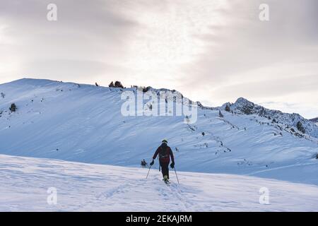 Männlicher Skifahrer beim Klettern in den Pyrenäen während des Sonnenaufgangs Stockfoto