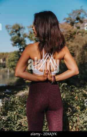 Reife Frau, die Yoga macht, während sie im öffentlichen Park steht Stockfoto