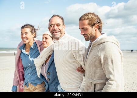 Gruppe von erwachsenen Freunden, die zusammen am Küstenstrand stehen Stockfoto