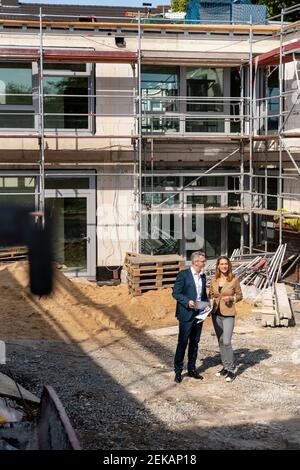 Architekt, der auf der Baustelle mit einem Kollegen diskutiert Stockfoto