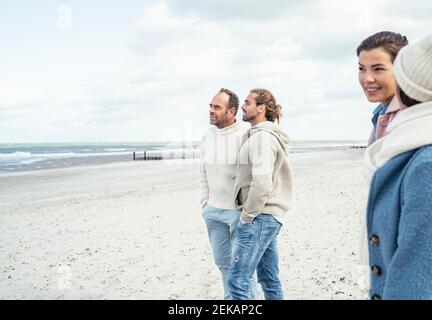 Gruppe von erwachsenen Freunden stehen und reden am Küstenstrand Stockfoto