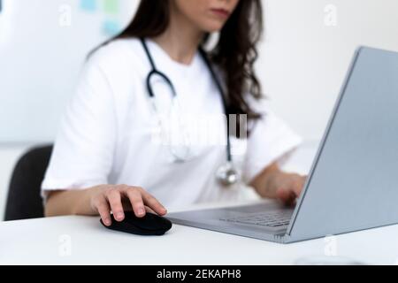 Junge Ärztin unter Online-Beratung durch Laptop in der Klinik Stockfoto