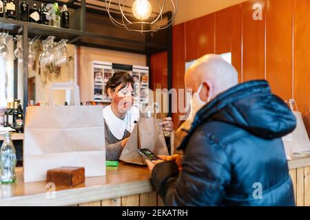 Reifer Gast im Restaurant, um Essen zum Mitnehmen abzuholen Während einer Pandemie Stockfoto