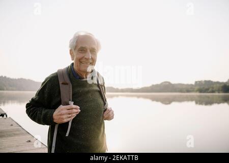 Senior Explorer mit Rucksack, während sie auf dem Pier stehen Stockfoto