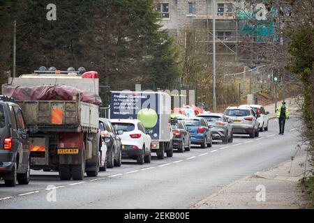 Schlange von Autos, die während des Coronavirus am psni Polizeikontrollpunkt warten Reisebeschränkungen Newtownabbey Nordirland Großbritannien Stockfoto