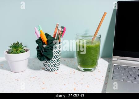 Saftige Pflanze, Laptop und gesunder grüner Saft über dem Schreibtisch zu Hause Stockfoto