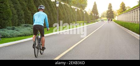 Kurzer Screenshot eines Mannes, der während des Sonnenuntergangs im Park Mountainbike fährt und an einem Sommertag im Freien radelt. Aktives Lifestyle-Konzept Stockfoto