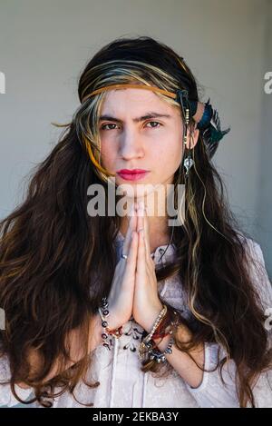 Hippie nachdenkliche junge Frau mit langen Haaren auf Stufen sitzend Stockfoto