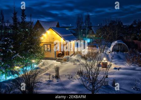 Schneebedeckte Dacha in einer Winterdämmerung Stockfoto