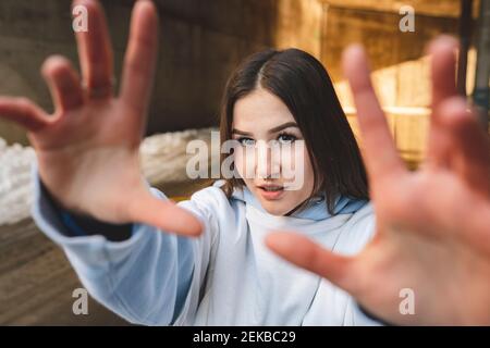 Frau streckt die Hand, während sie gegen die Unterführung steht Stockfoto