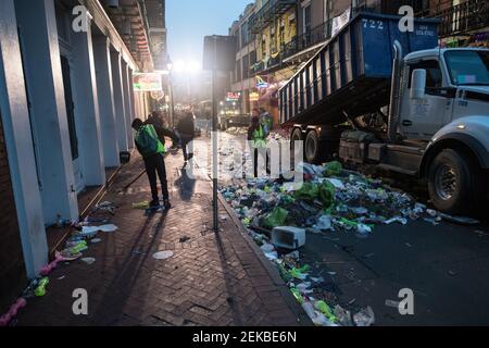 Sanitärangestellte stellen sich der gewaltigen Aufgabe, die mit Müll übersäte Bourbon Street im Gefolge der Mardi Gras-Feierlichkeiten in New Orleans zu säubern. Stockfoto