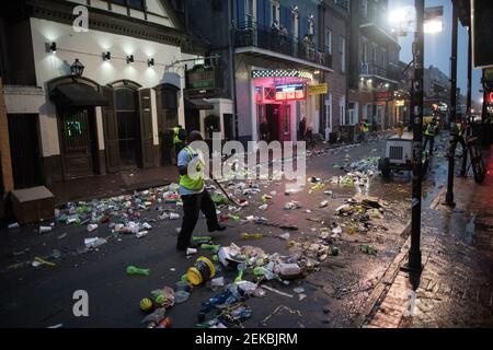 Sanitärangestellte stellen sich der gewaltigen Aufgabe, die mit Müll übersäte Bourbon Street im Gefolge der Mardi Gras-Feierlichkeiten in New Orleans zu säubern. Stockfoto