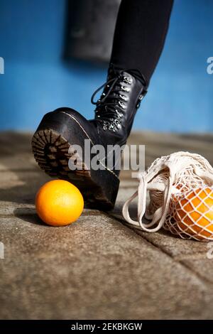 Frau Fuß über orange Frucht auf Fußweg Stockfoto