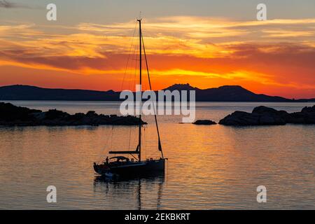 Golden, Sunset View, vertäute Yacht auf ruhigen Gewässern von Sardinien über ein ruhiges Mittelmeer zu den Inseln La Madallena und Caprera Stockfoto