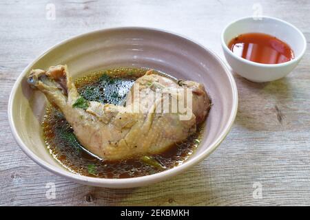 Gekochte Hühnerschenkel und Bein mit Kräutersuppe in Schüssel Tauchen würzige Chili-Sauce Tasse Stockfoto