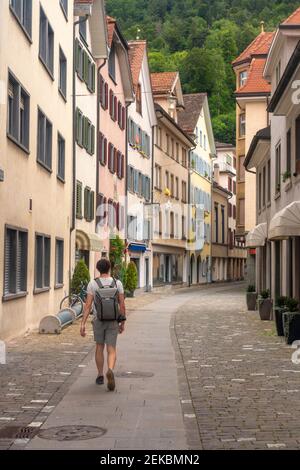 Explorer mit Rucksack zu Fuß auf der Storchengasse in der Altstadt von Chur, Schweiz Stockfoto