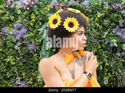 Weibliche Hipster Blick weg gegen Pflanzen Stockfoto