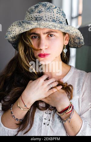 Nahaufnahme einer stilvollen jungen Frau, die im Innenbereich einen Hut trägt Stockfoto