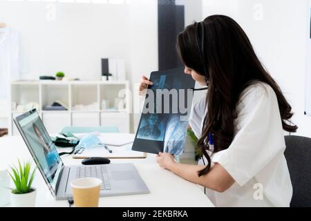 Ärztin, die Rat gibt, während sie online über Laptop berät Klinik Stockfoto