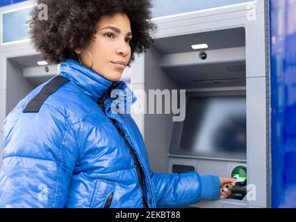 Afro Frau, die Fahrkarte vom Ticketautomaten entfernt, während sie im Bus steht Stopp Stockfoto