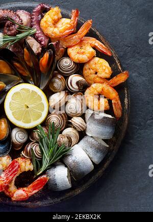 Fischbrettkarton mit Garnelen, Austern, Fisch und Tintenfisch. Draufsicht, Nahaufnahme Stockfoto
