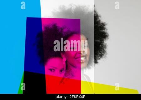 Lächelnde Afro-Frau mit Grundfarben vor weißem Hintergrund Stockfoto