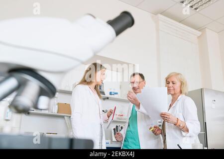 Wissenschaftler in weißen Mänteln arbeiten im Labor zusammen Stockfoto