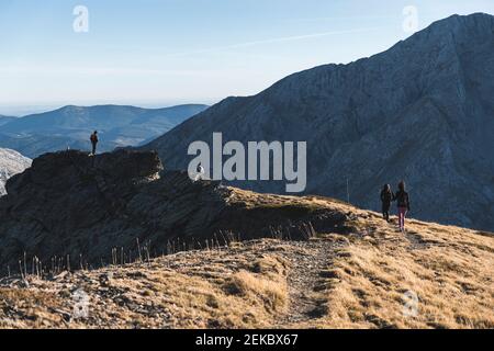 Wanderfreunde und Wanderinnen erkunden in Berg gegen Himmel Stockfoto