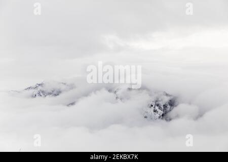 Wolken bedecken schneebedeckten Berg Stockfoto