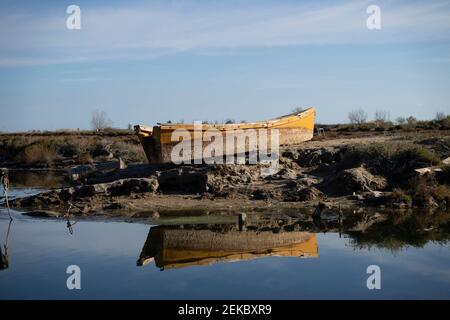 Verlassene Boot am Flussufer gegen den Himmel im Naturpark Ebro Delta, Spanien vertäut Stockfoto