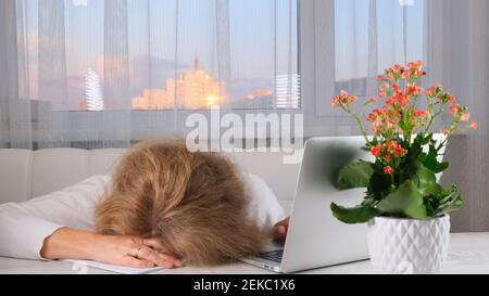 Müde Geschäftsfrau am Arbeitsplatz, hält ihren Kopf in den Händen. Überarbeiten, Fehler machen, Stress, Depression Konzept. Stockfoto