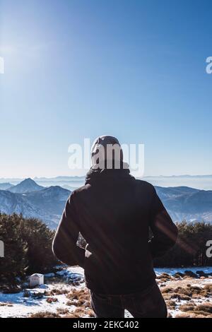 Mann, der auf die Aussicht schaut, während er auf schneebedecktem Land steht Stockfoto