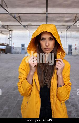 Schöne Tänzerin in gelber Jacke in verlassenen Fabrik Stockfoto
