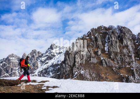 Mann, der auf schneebedecktem Land in Richtung Berg geht Stockfoto