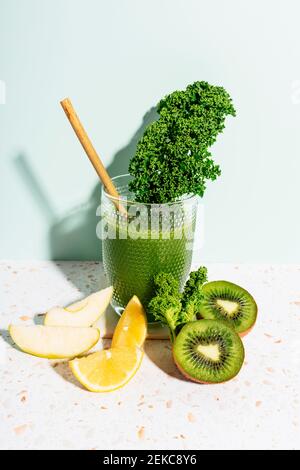 Gesunder grüner Saft mit Apfel, Zitrone, Grünkohl, Kiwi und Sellerie gegen die Wand Stockfoto