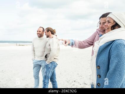 Gruppe von erwachsenen Freunden stehen und reden am Küstenstrand Stockfoto